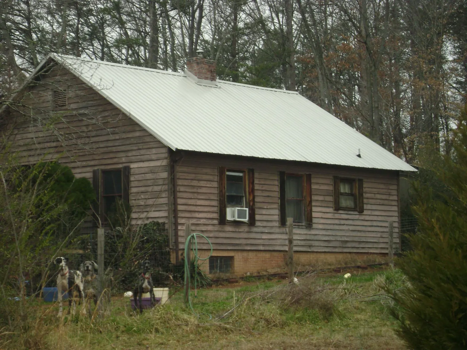 White metal roof on an old wood sided farmhouse, from a Metal Roof Installation job in Andale